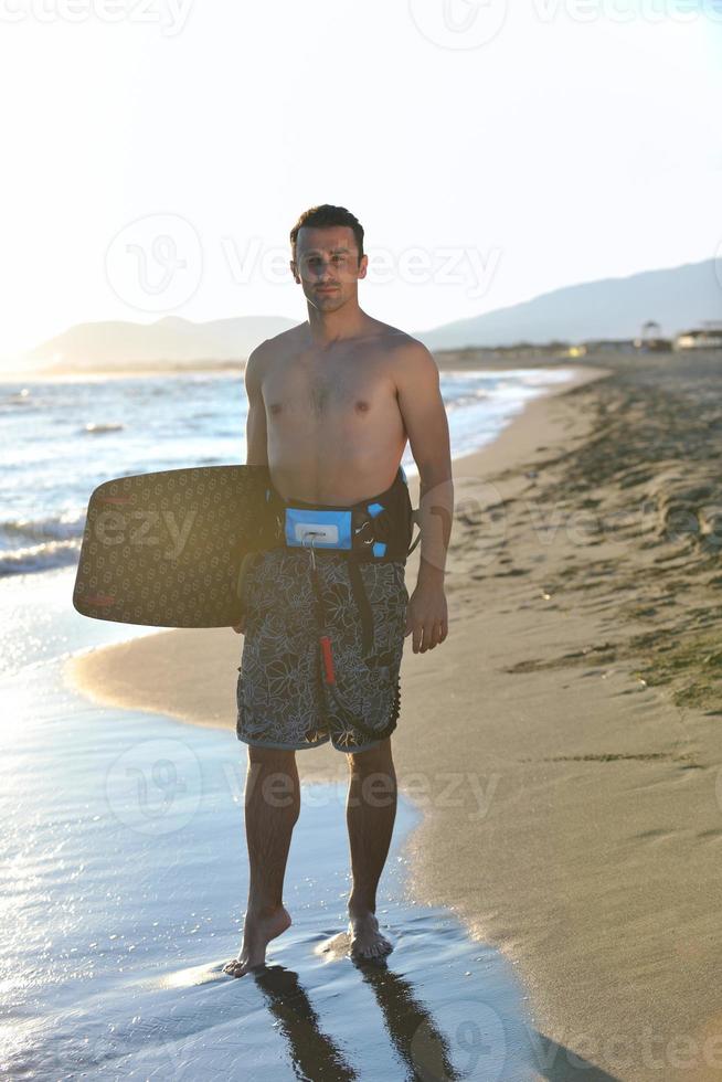 Portrait of a young  kitsurf  man at beach on sunset photo