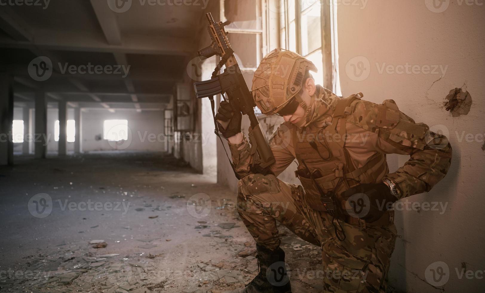 soldier in action near window changing magazine and take cover photo