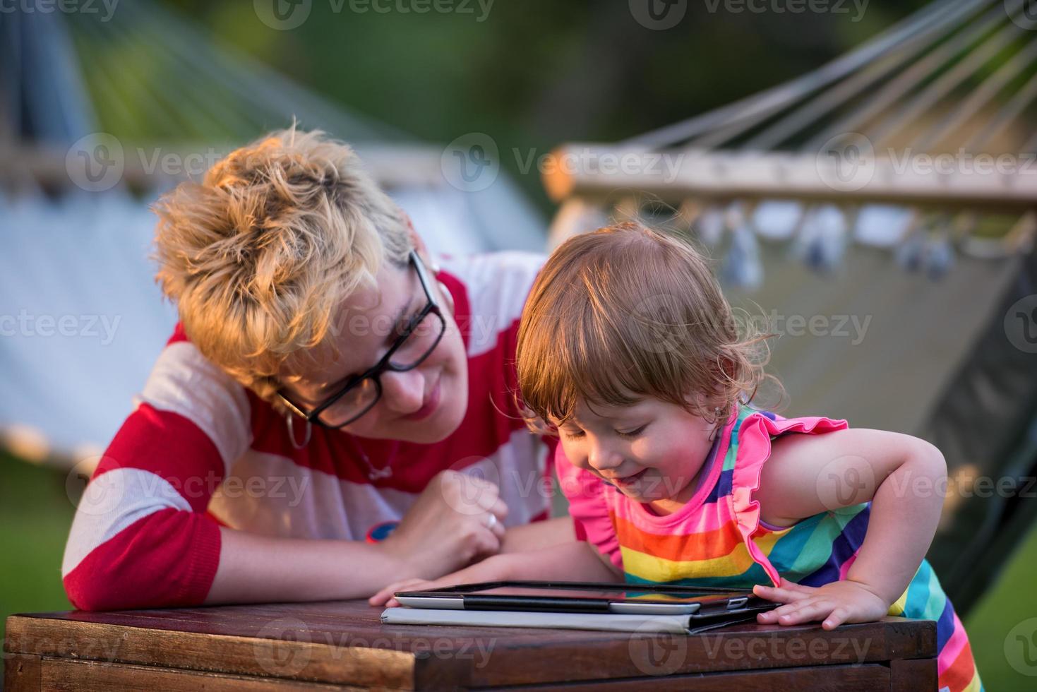 mom and her little daughter using tablet computer photo