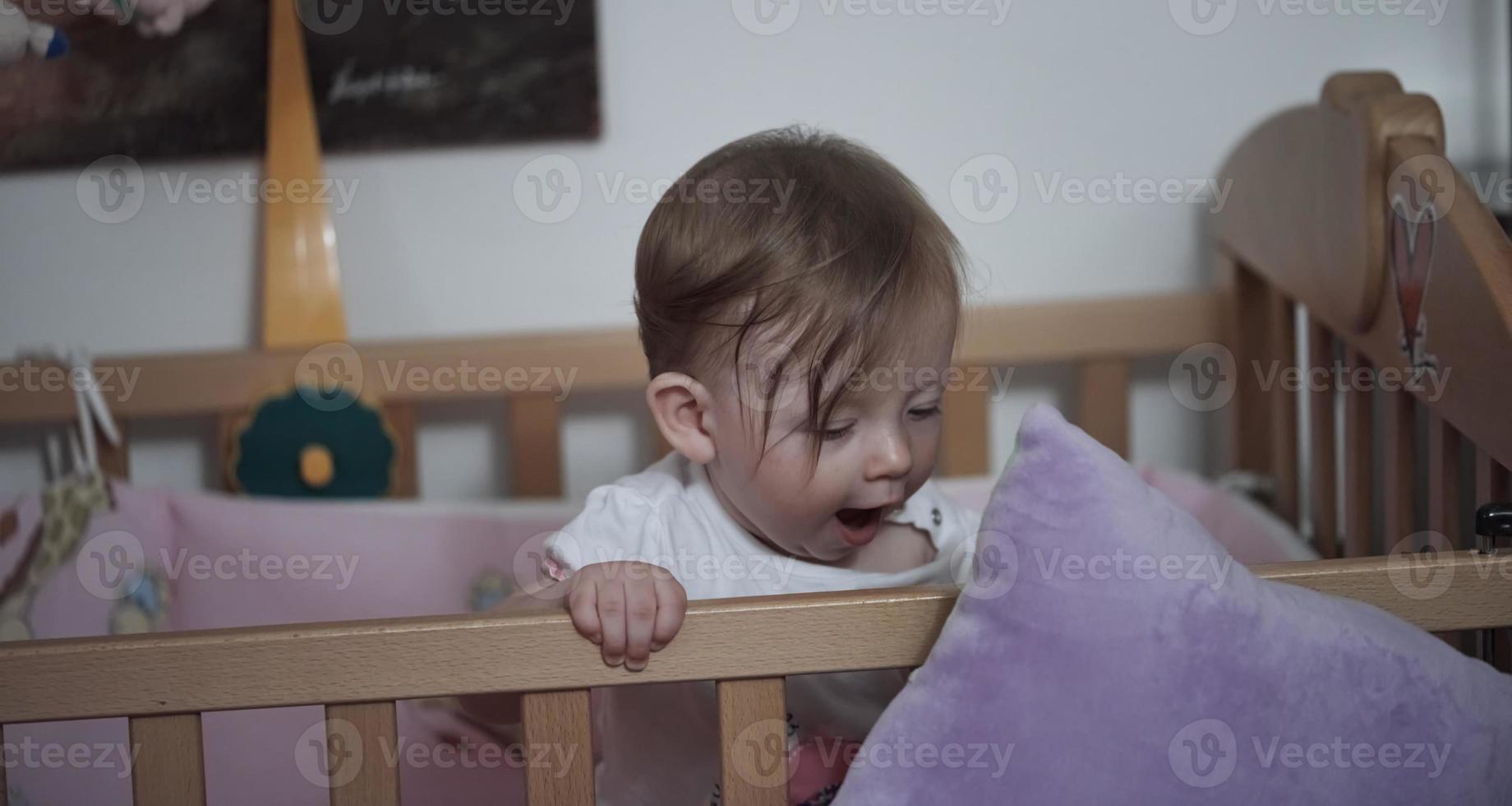 cute  little one year old baby and making first steps in bed photo