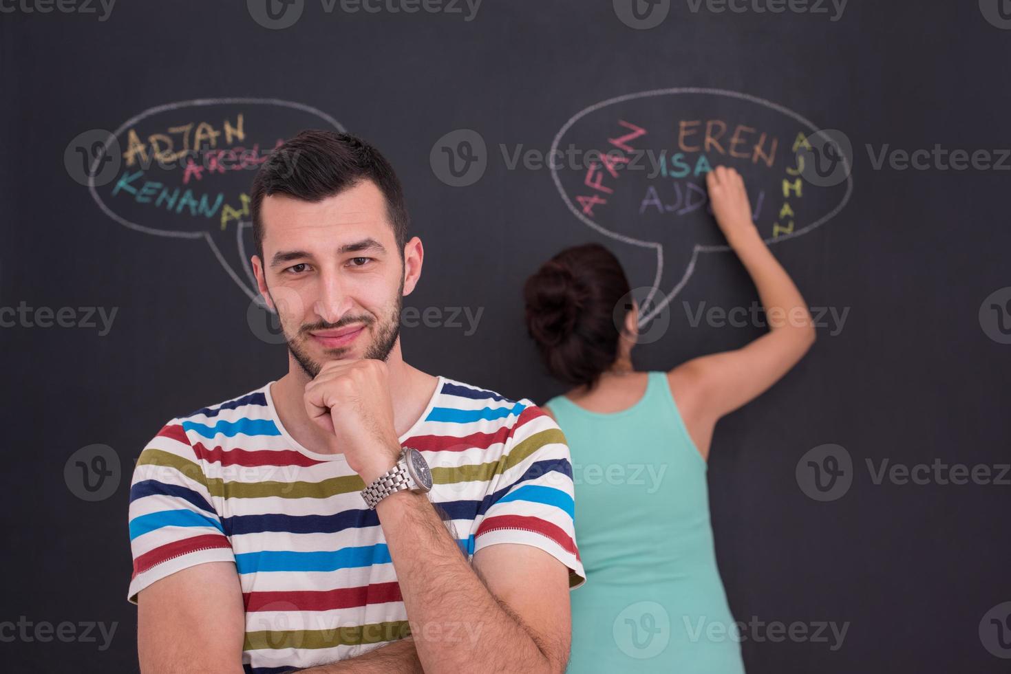 pregnant couple writing on a black chalkboard photo