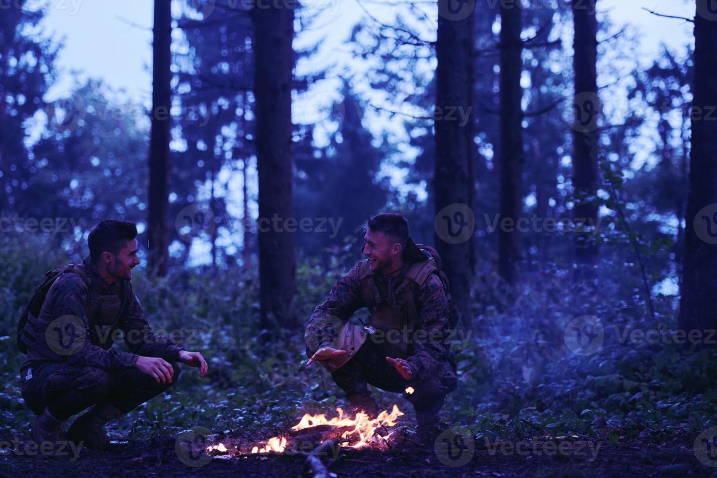 soldiers resting by fire in forest photo