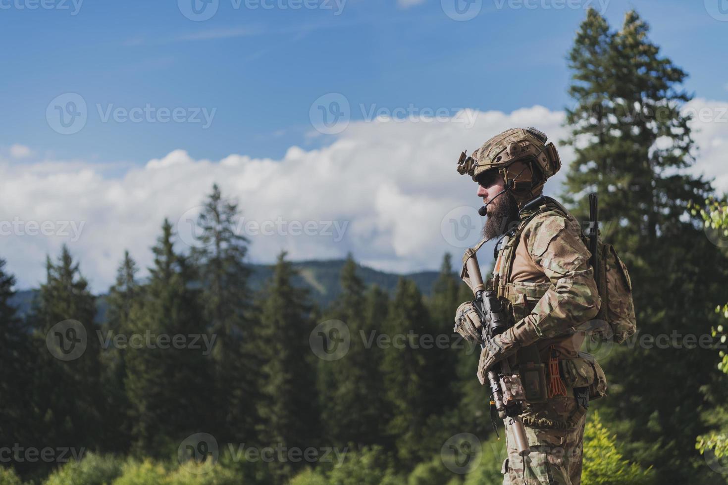 War concept. A bearded soldier in a special forces uniform fighting an enemy in a forest area. Selective focus photo