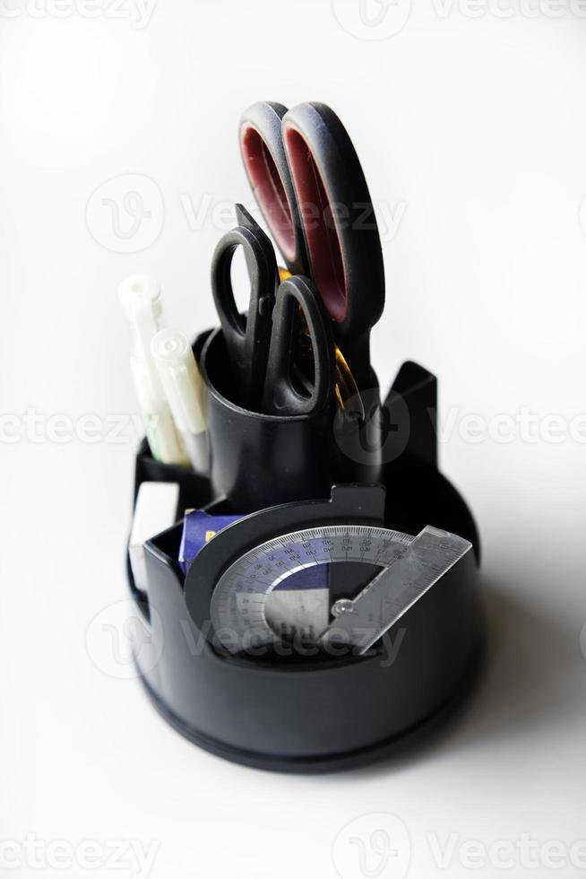 Black office organizer with scissors ruler pens and stapler. photo