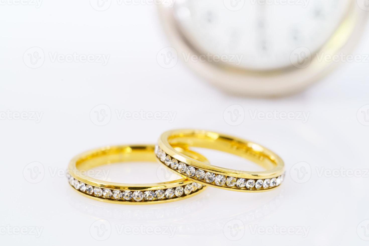 dos anillos de boda dorados en blanco foto