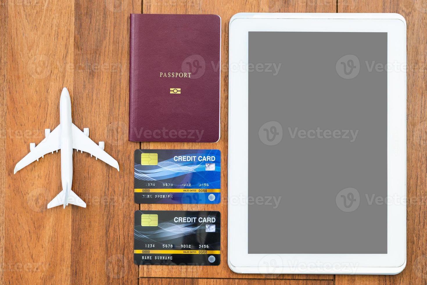 Top view Passport with credit card and digital tablet mock up on wooden desk photo