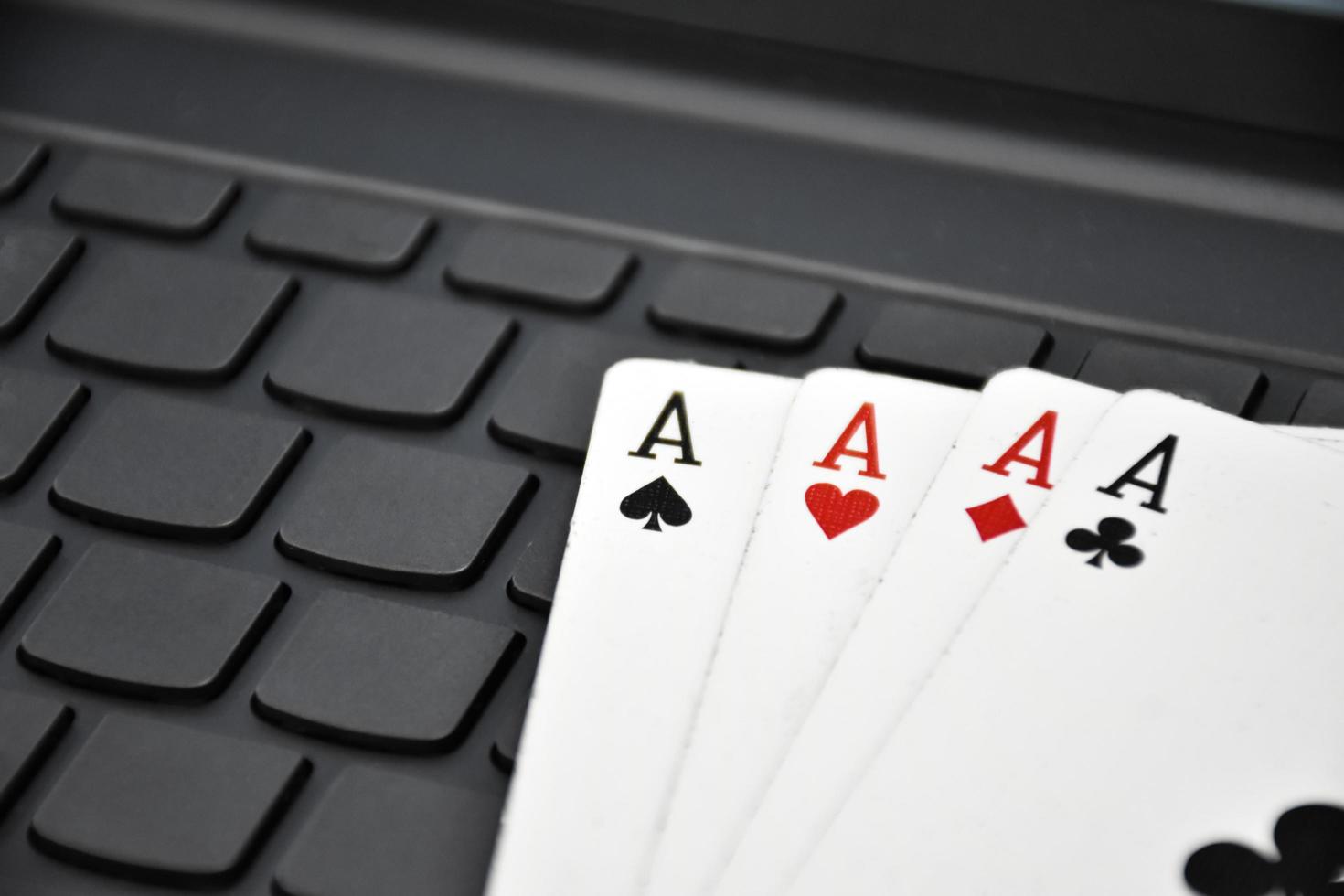 Paper cards on blank laptop keyboard, soft and selective focus, concept for playing cards online with other people at home and recreational activity. photo