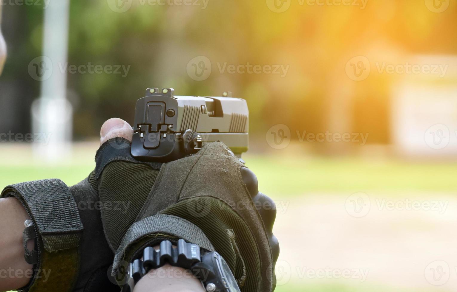 Pistola automática de 9 mm sujeta en la mano derecha del tirador, concepto de seguridad, robo, gángster, guardaespaldas en todo el mundo. enfoque selectivo en pistola. foto