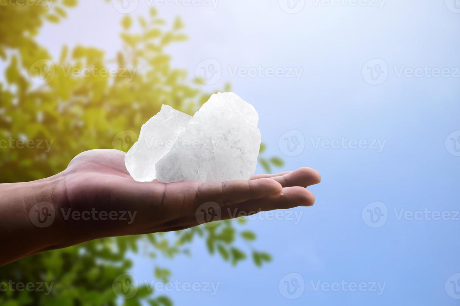 White alum bar holding in hand with cloudy water, concept for using alum to sway or swing the cloudy water to be clean and clear before using it in human daily life, soft and selective focus. photo