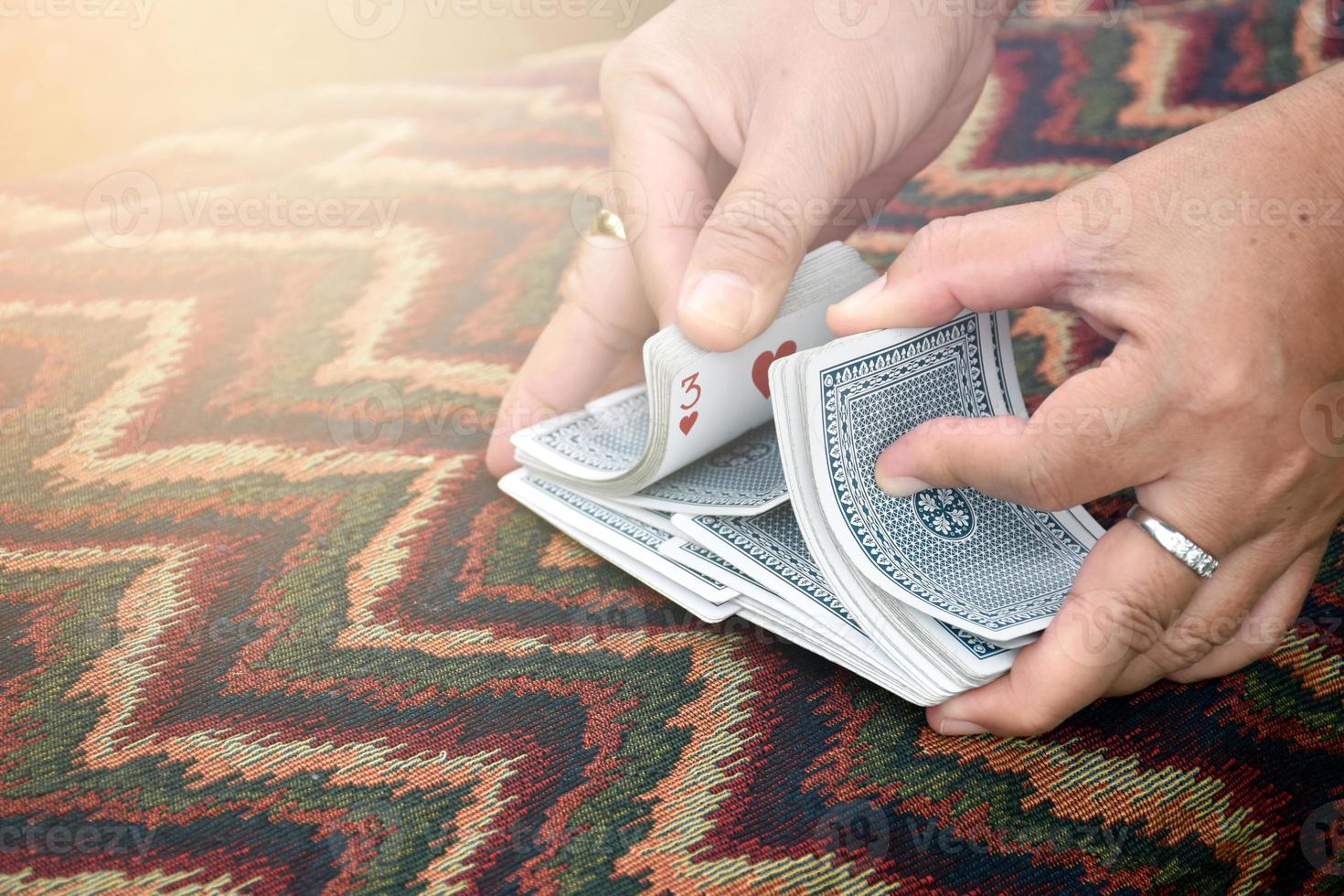 The female poker player is shuffling pokers in her hands before handling the poker cards to the other poker players, soft and selective focus on poker cards. photo