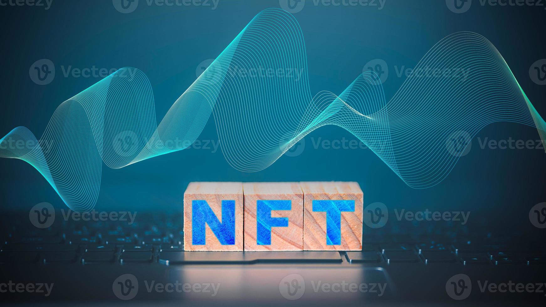 NFT word on wooden cube block which is placed on a laptop. NFT non fungible tokens concept. photo