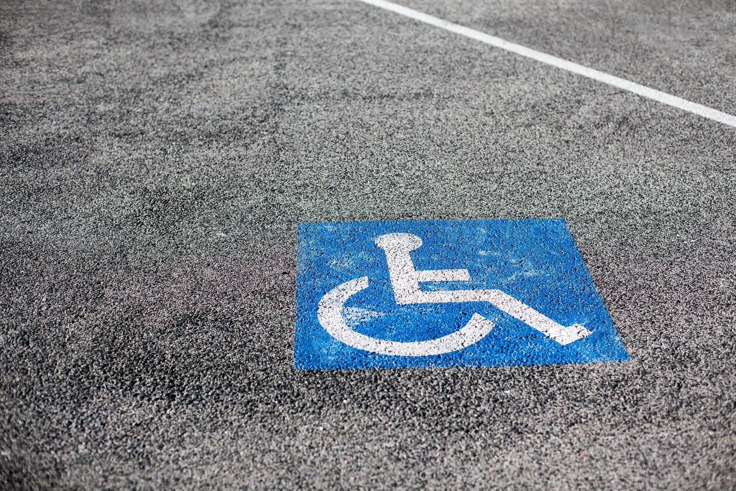 Handicapped parking spot, blue square on asphalt photo