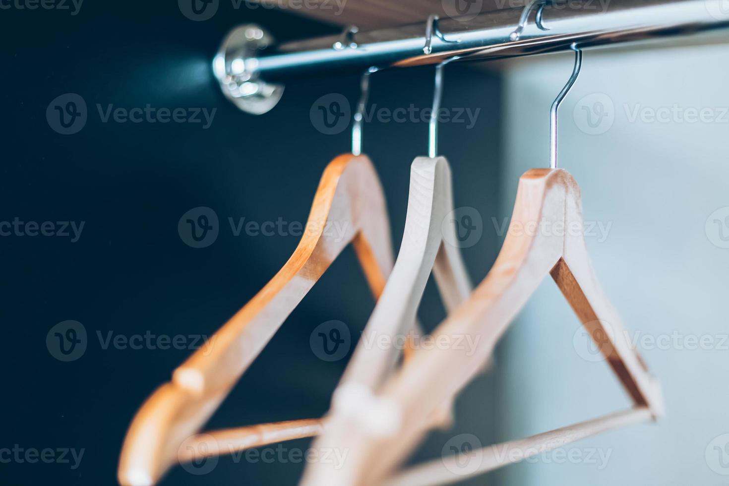 Empty Wooden hangers on rail in closet photo