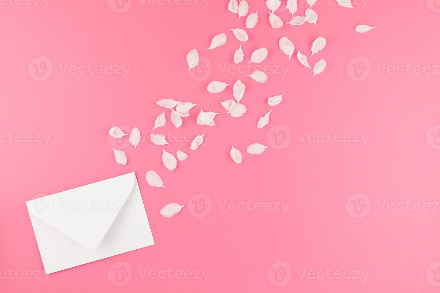 Flat lay of white letter mock up with petals photo
