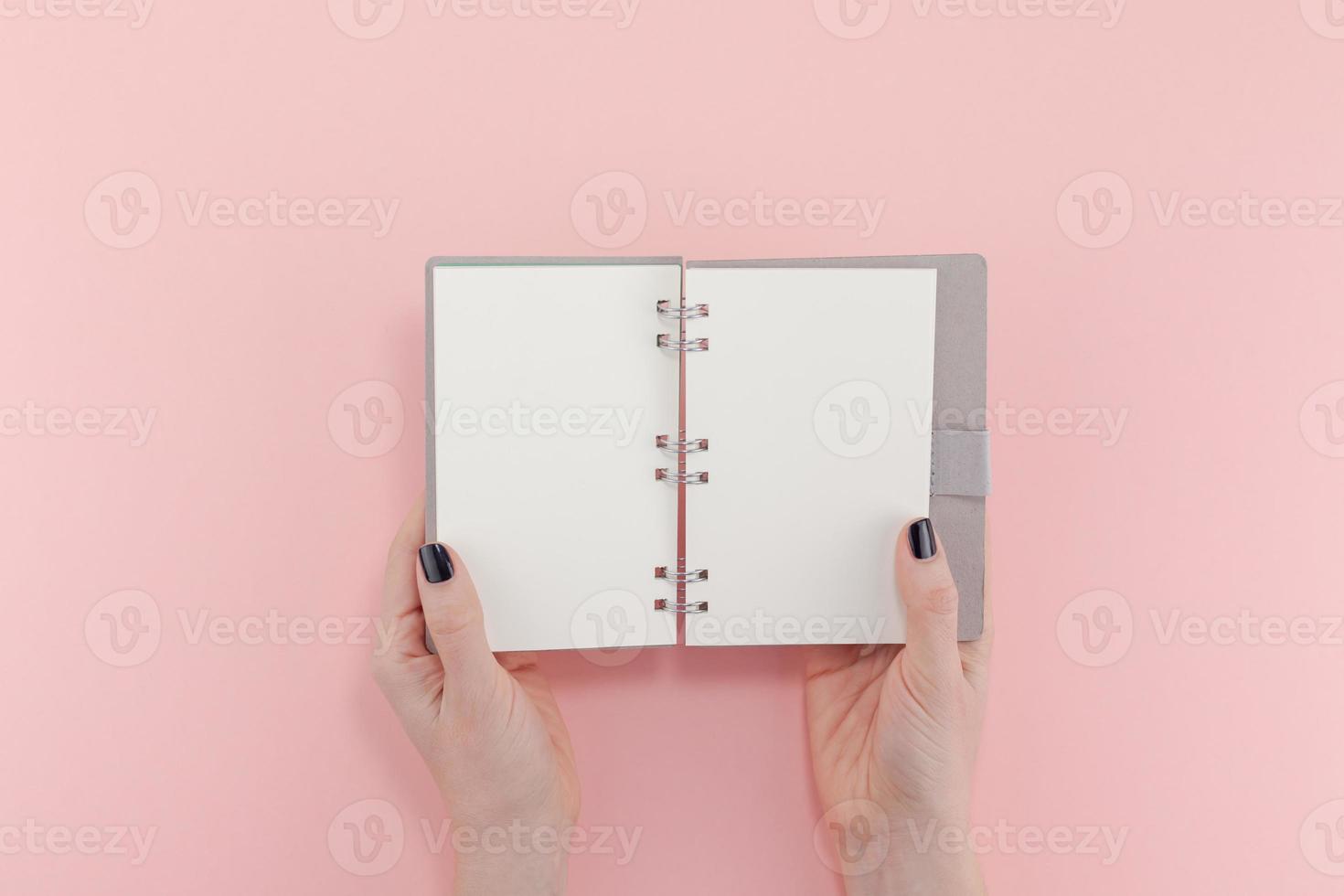 manos de mujer con maqueta de bloc de notas en blanco foto