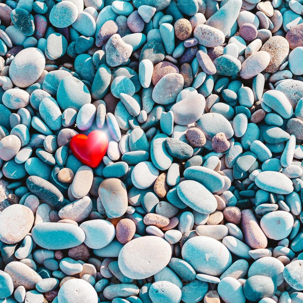 símbolo romántico de corazón rojo en la playa de guijarros foto