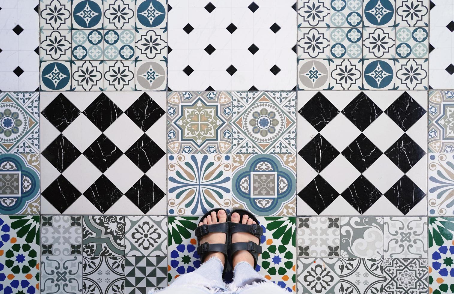 Top view selfie of feet in sandals shoes on the various vintage seamless floor background with copy space, fashion lifestyle photo