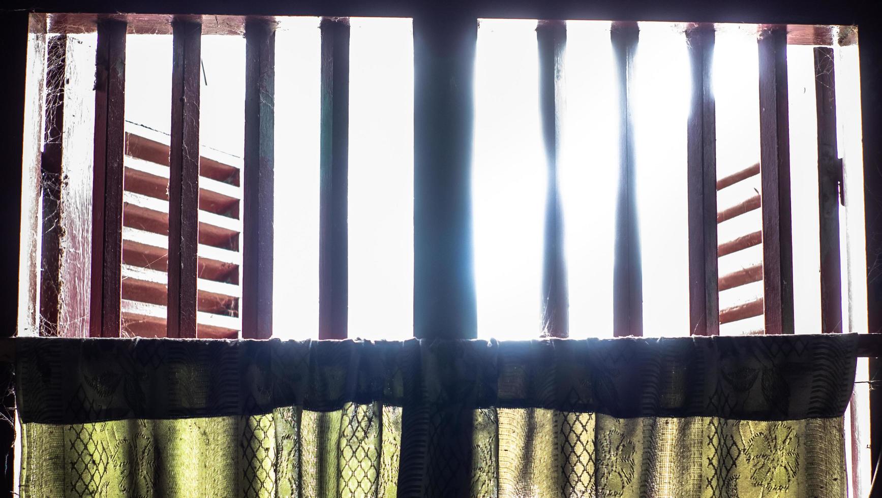 the window of the house opens with a little light entering the silhouette photo