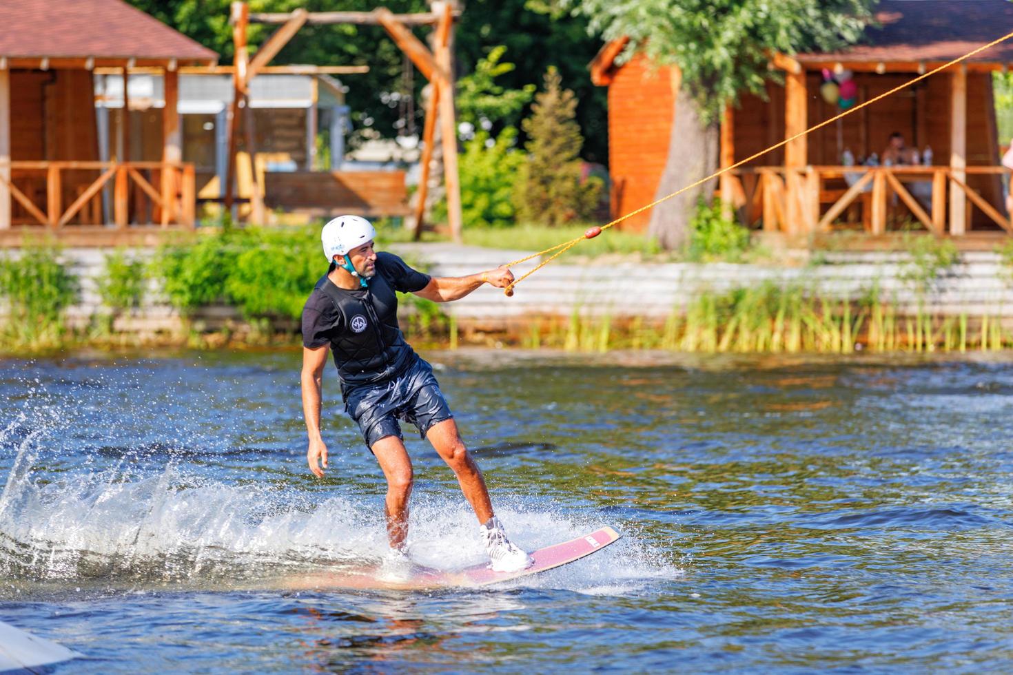 Athlete man rides on a water board on a summer day on a blurred background. 06.19.1922. Kyiv. Ukraine. photo