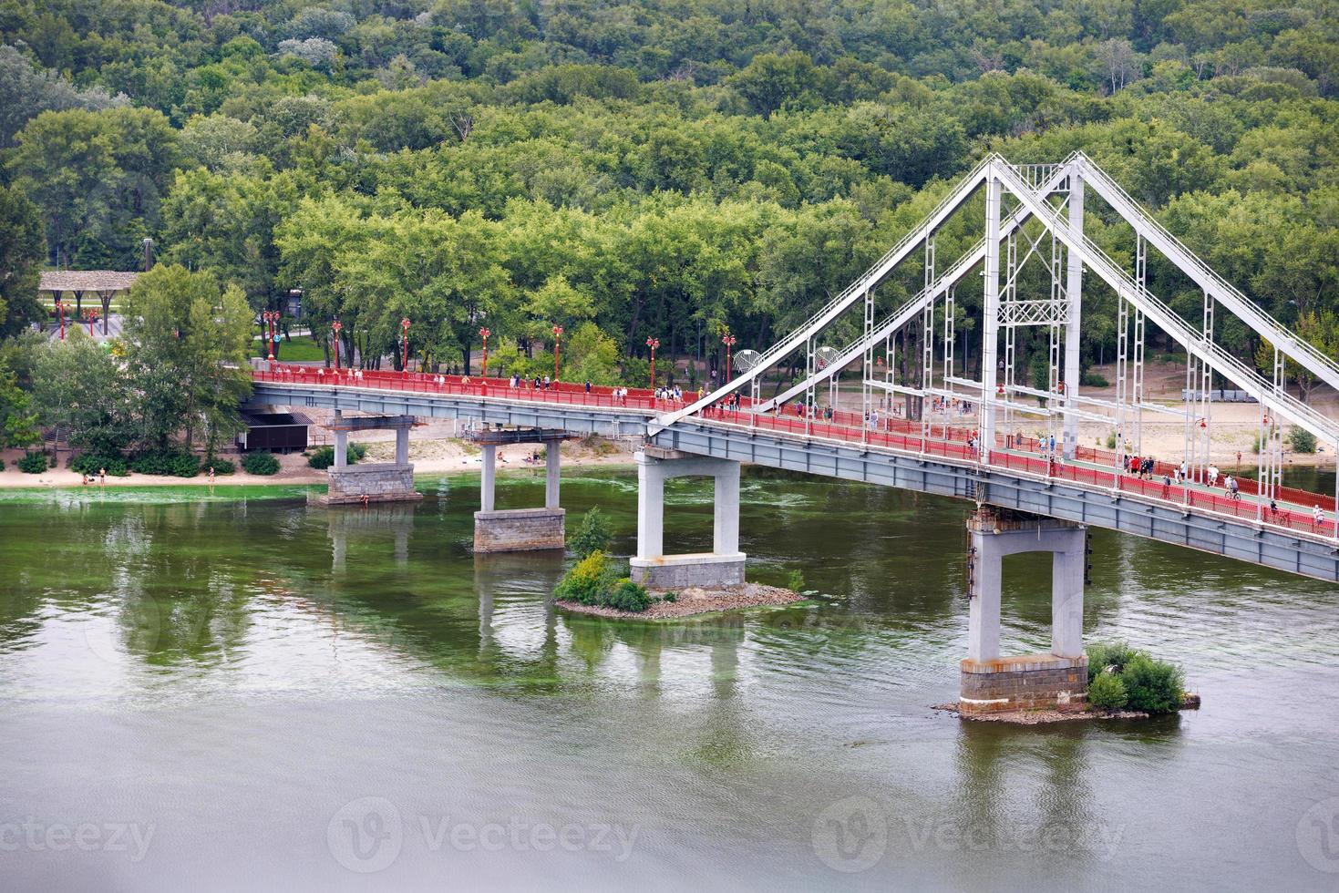 View of the pedestrian bridge across the Dnipro river in Kyiv on a summer day. photo