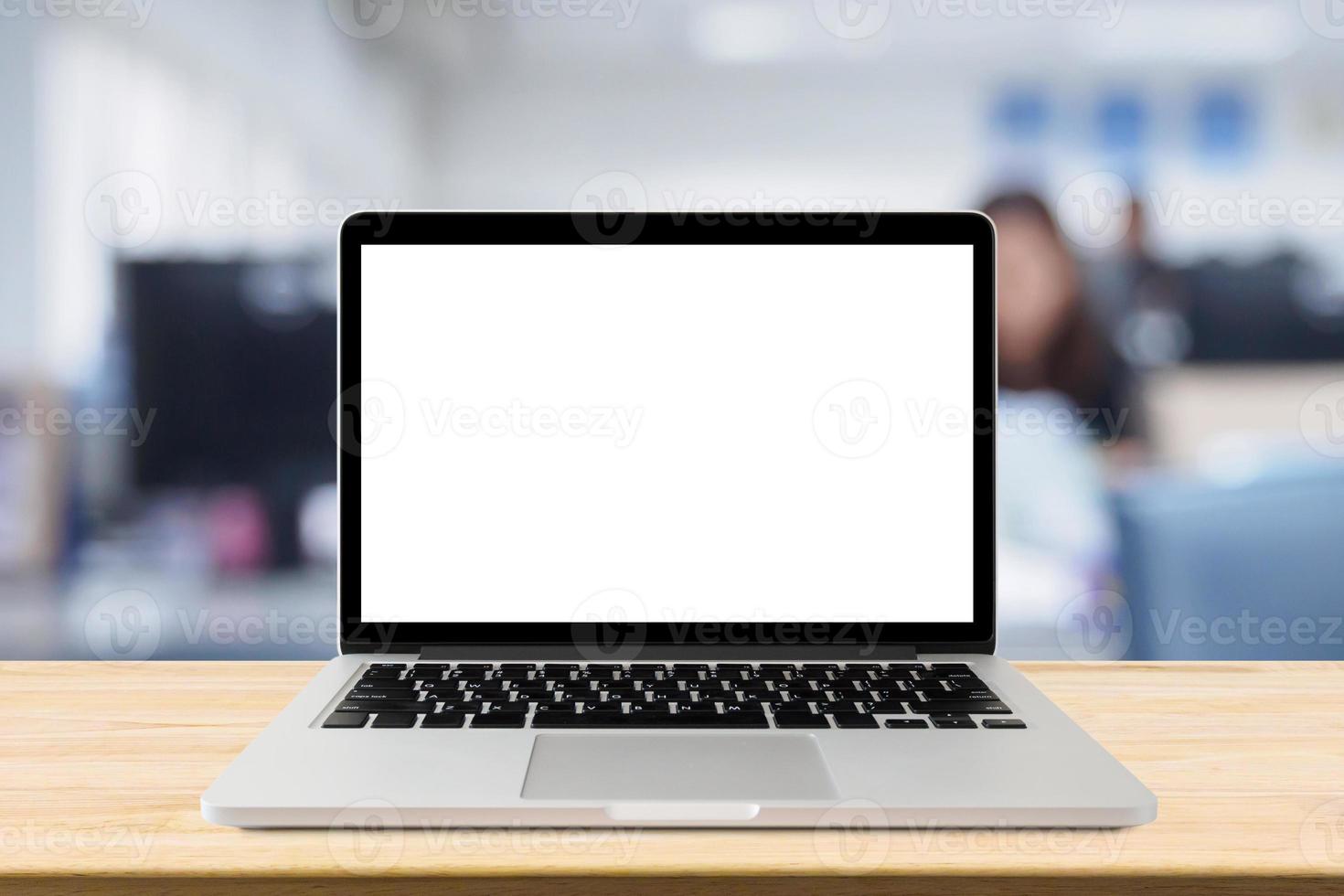 Laptop with blank screen on desk table with blur office interior background photo