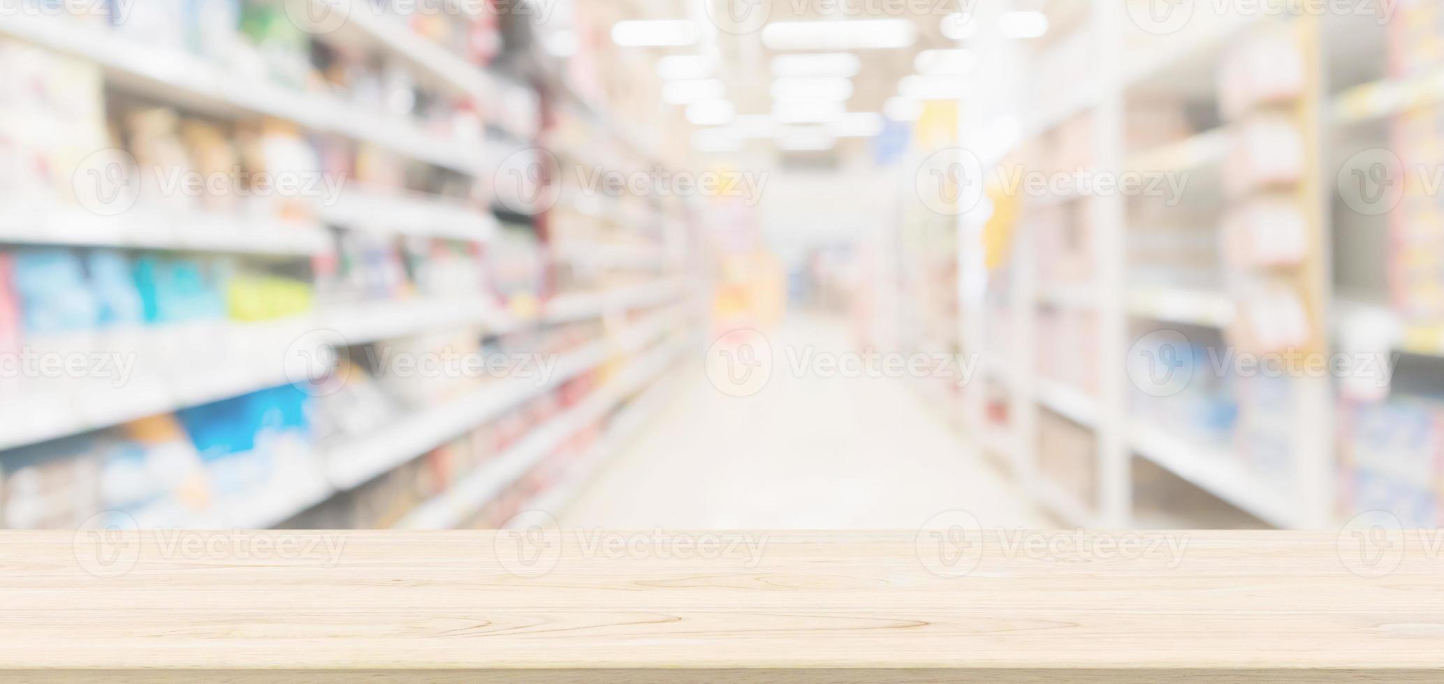 Wood table top with supermarket aisle blur background for product display photo