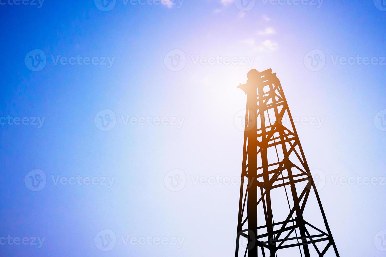 Silhouette pile driver at construction site photo