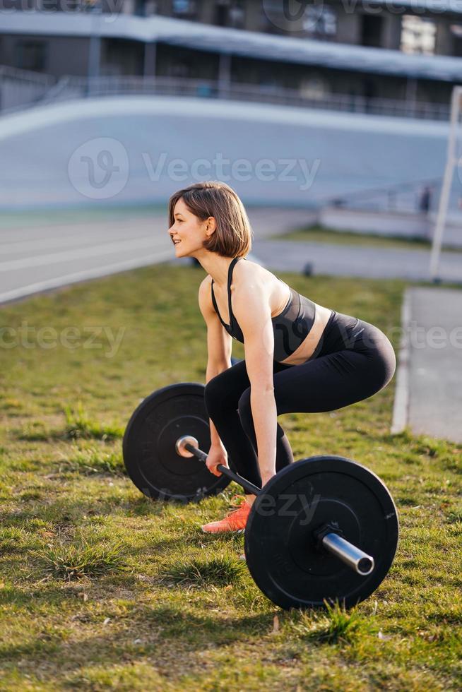 Strong woman exercising with barbell. Sports, fitness concept. photo