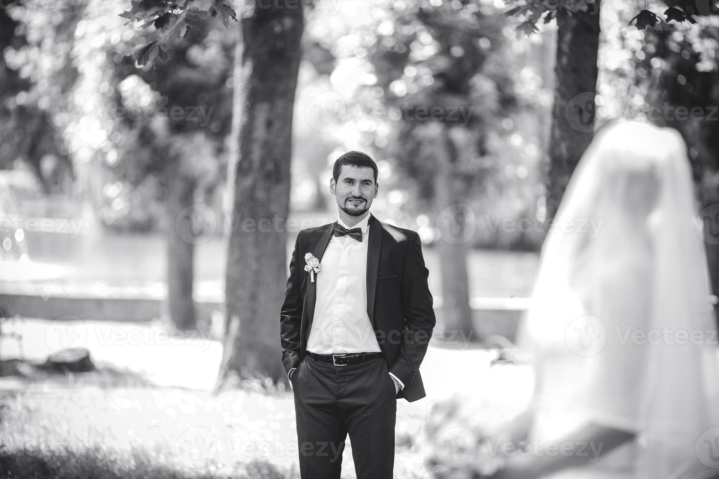 groom standing behind the bride photo