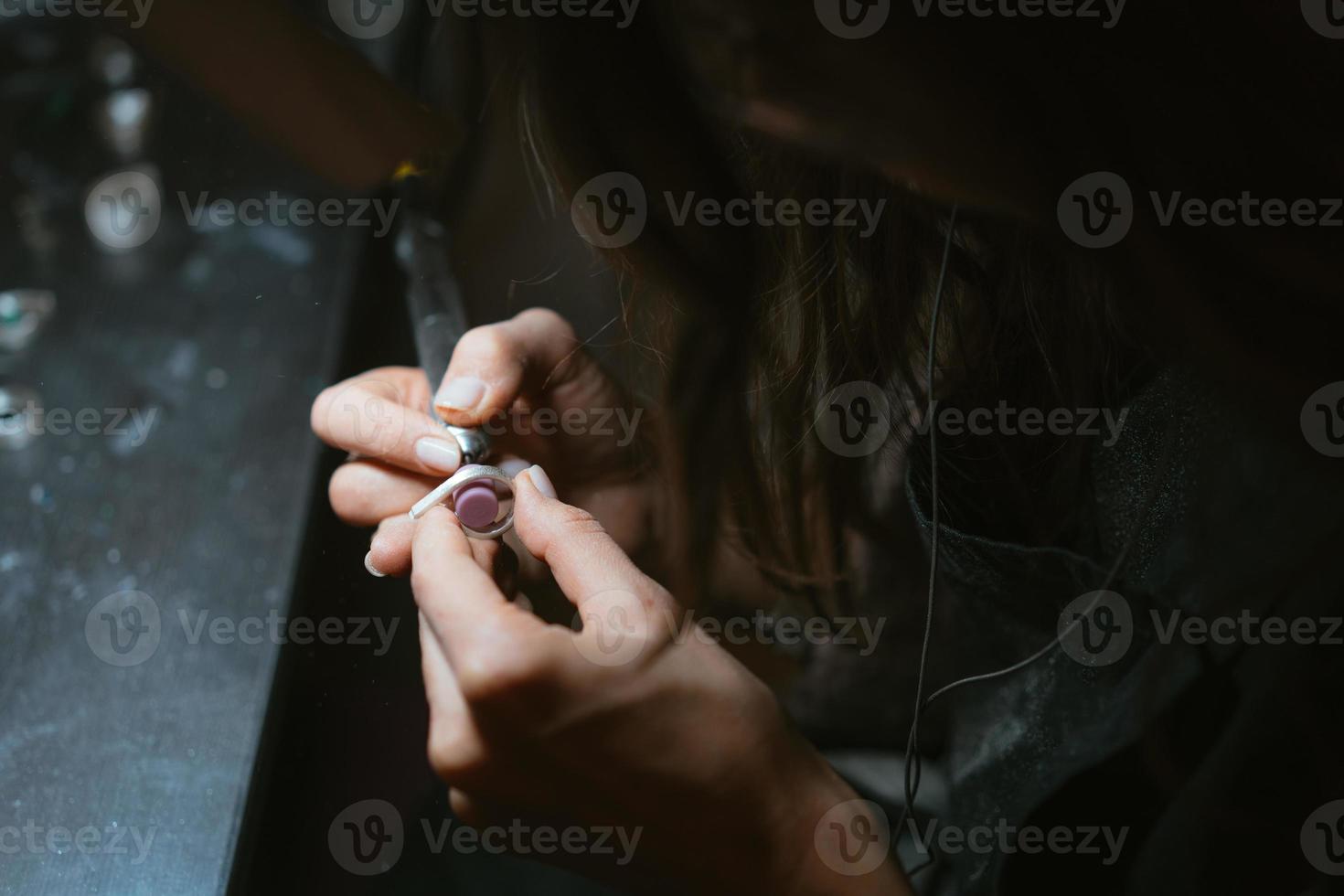 girl master processes the metal plate in the home workshop photo