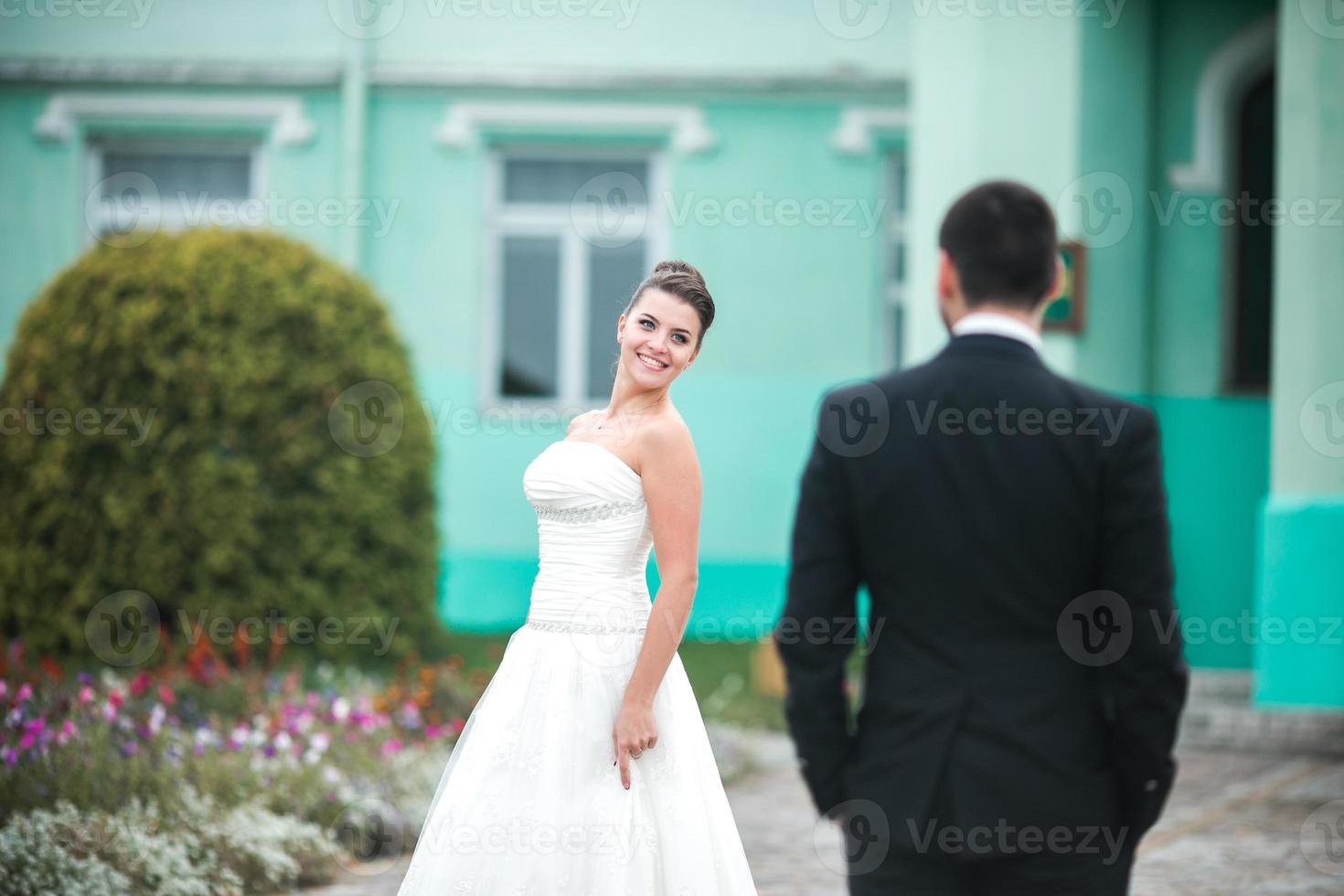 Beautiful wedding couple standing opposite each other photo