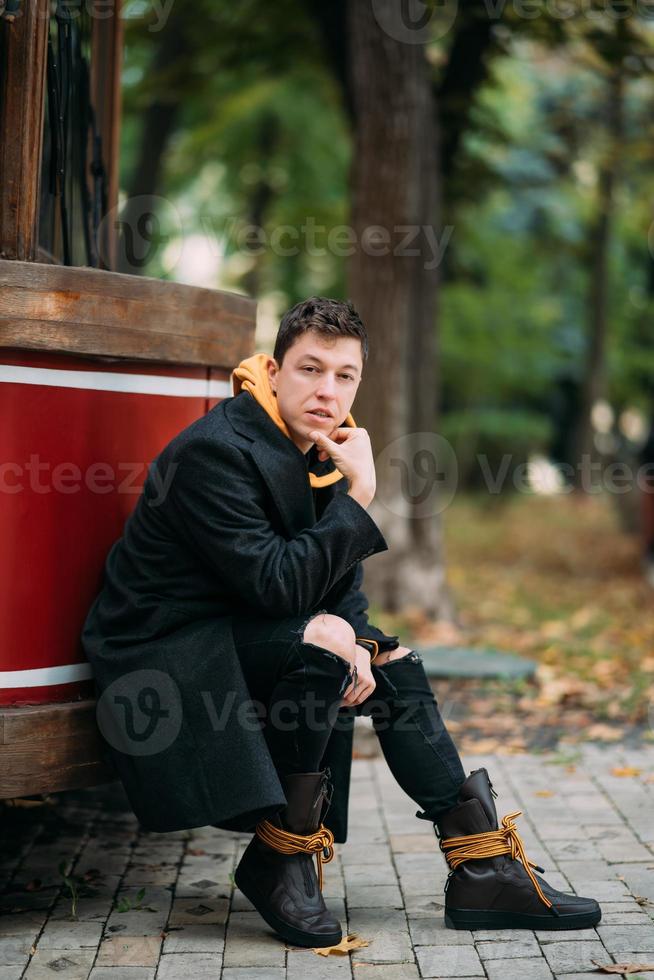 Young man in formal clothes walks in the autumn park. photo