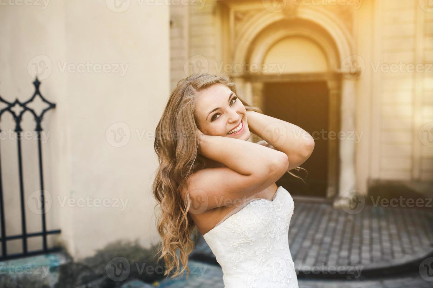 Beautiful bride posing against the backdrop of a European city photo