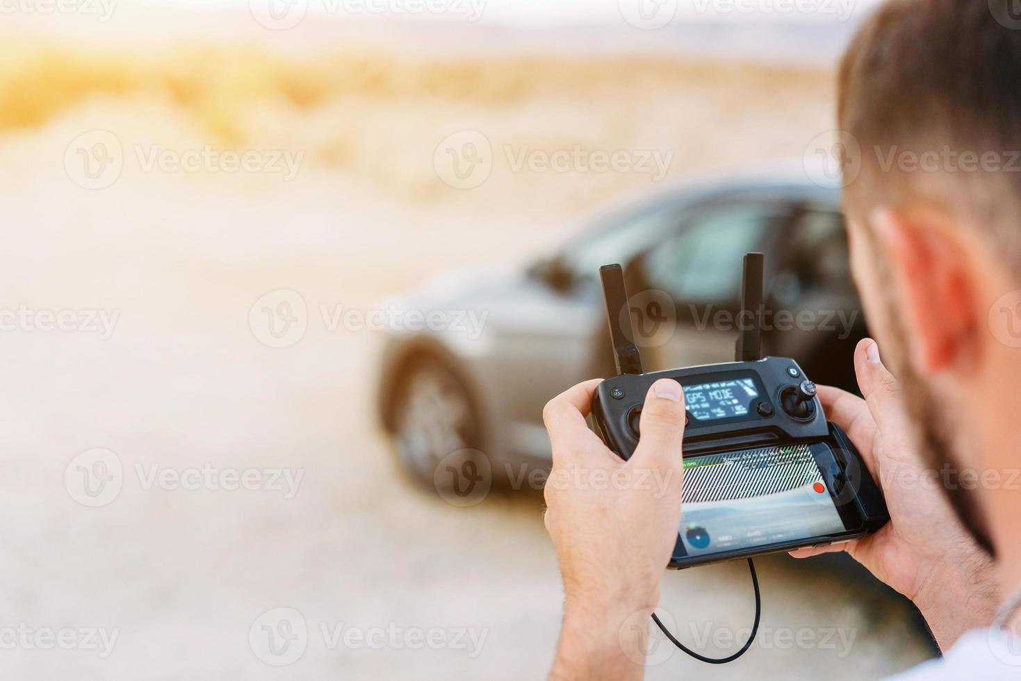 Guy controls drone with remote control photo