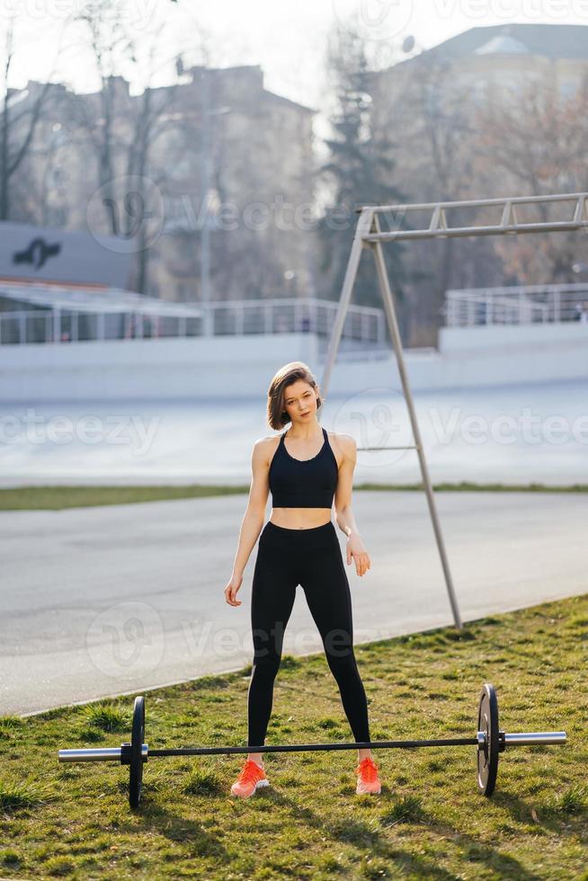 Strong woman exercising with barbell. Sports, fitness concept. photo