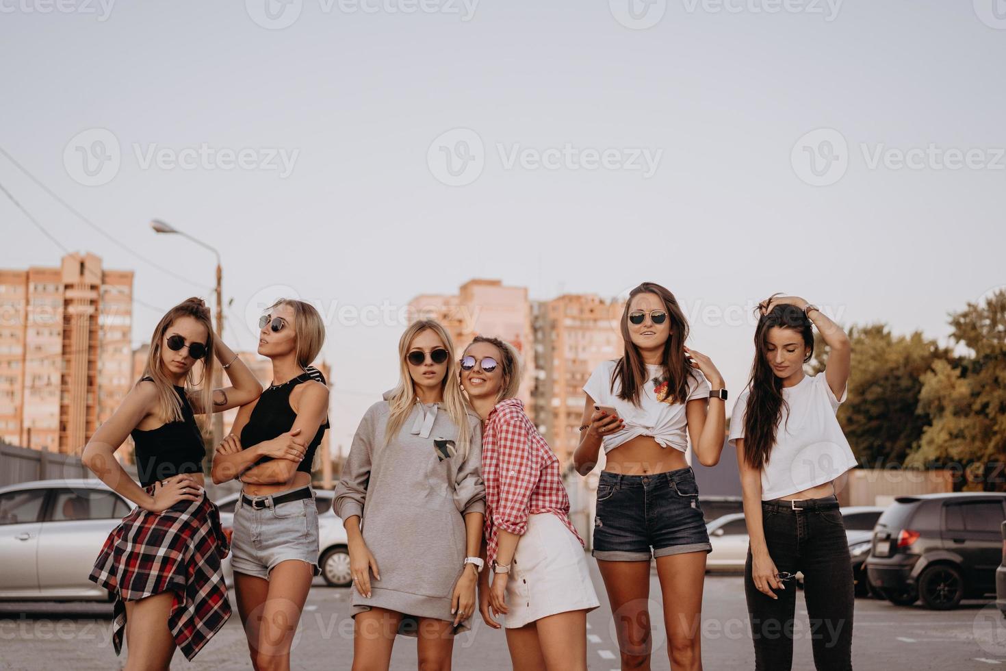 Six young women have fun at the car park. photo