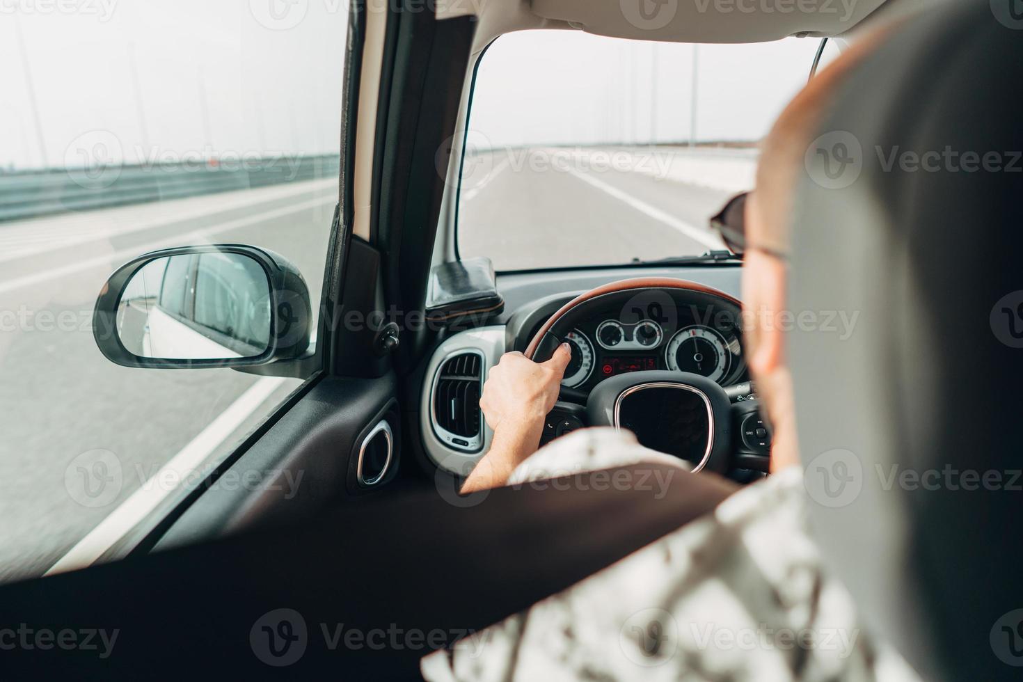 The man in the car traveling on the road photo