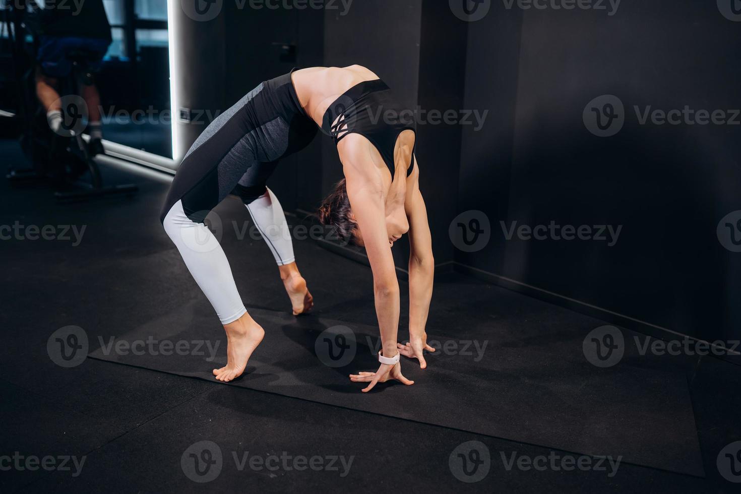 Slim athletic woman doing exercise bridge at gym photo