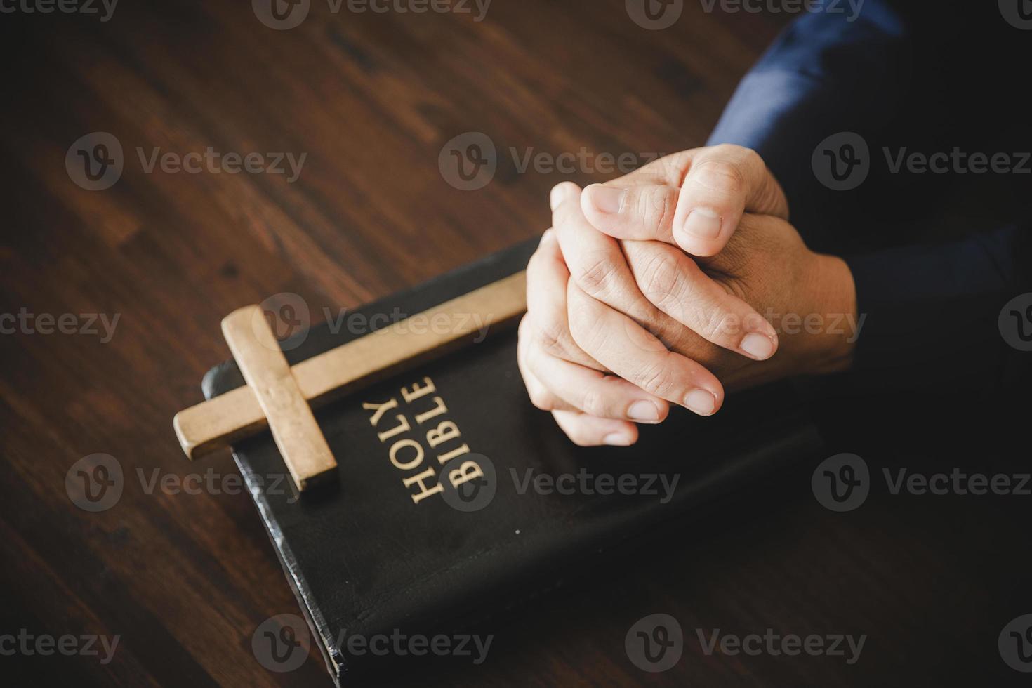 Hand folded in prayer to god on Holy Bible book in church concept for faith, spirituality and religion, woman person praying on holy bible in morning. christian catholic woman hand with Bible worship. photo