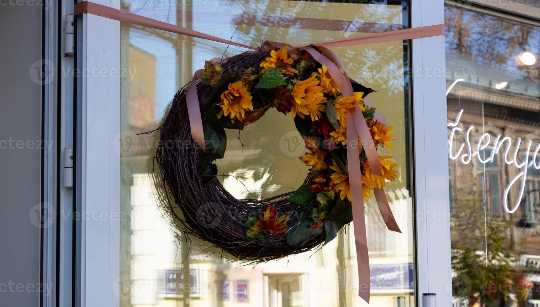 hermosa corona decorativa de plantas secas y flores colgadas en la puerta, primer plano aislado foto