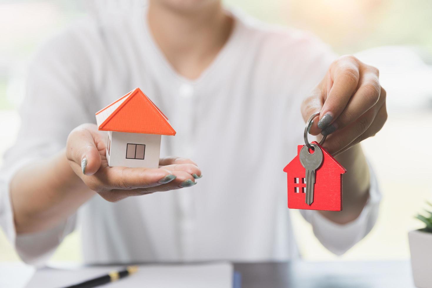 Real estate agent with house model and keys, Building, mortgage, real estate and property concept. photo