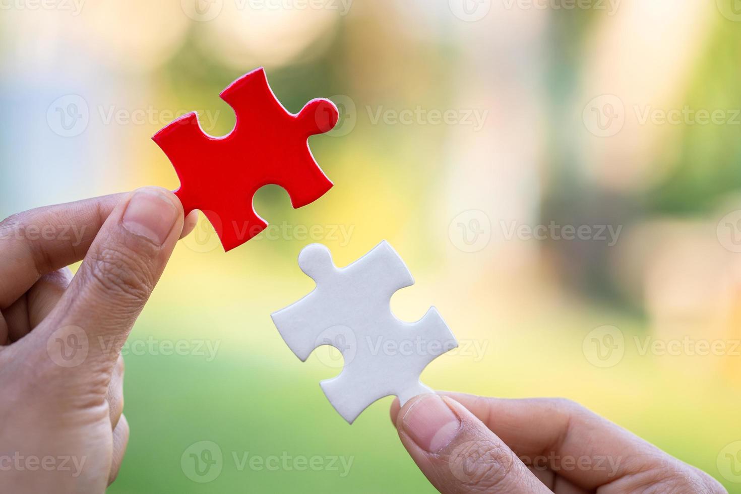 Closeup hand of connecting jigsaw puzzle to complete the mission with sunlight effect, Business solutions, success and strategy concept photo