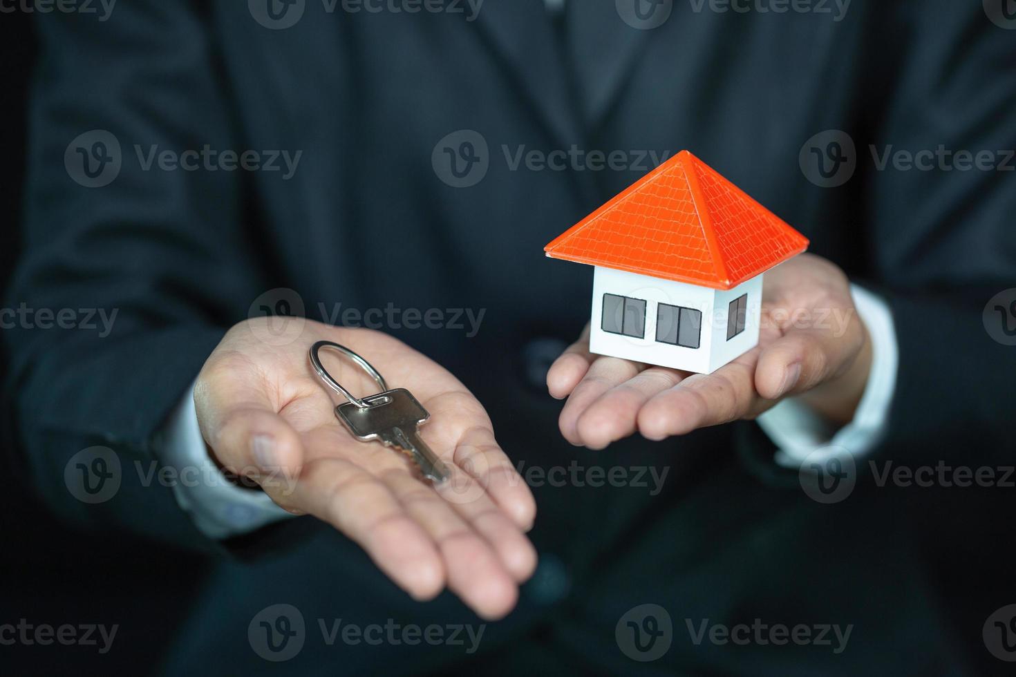 Real estate agent with house model and keys, Concept of real estate investment. photo