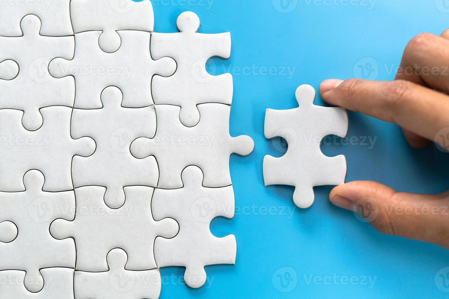 Two women are trying to connect a pair of puzzle pieces. Symbol of association and connection. Concept of business strategy. photo