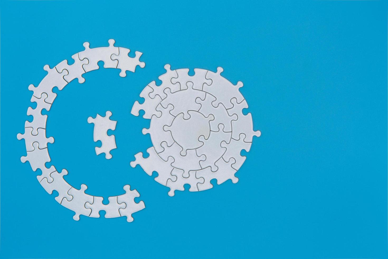 white jigsaw puzzle pieces on blue background,  Copy space. photo