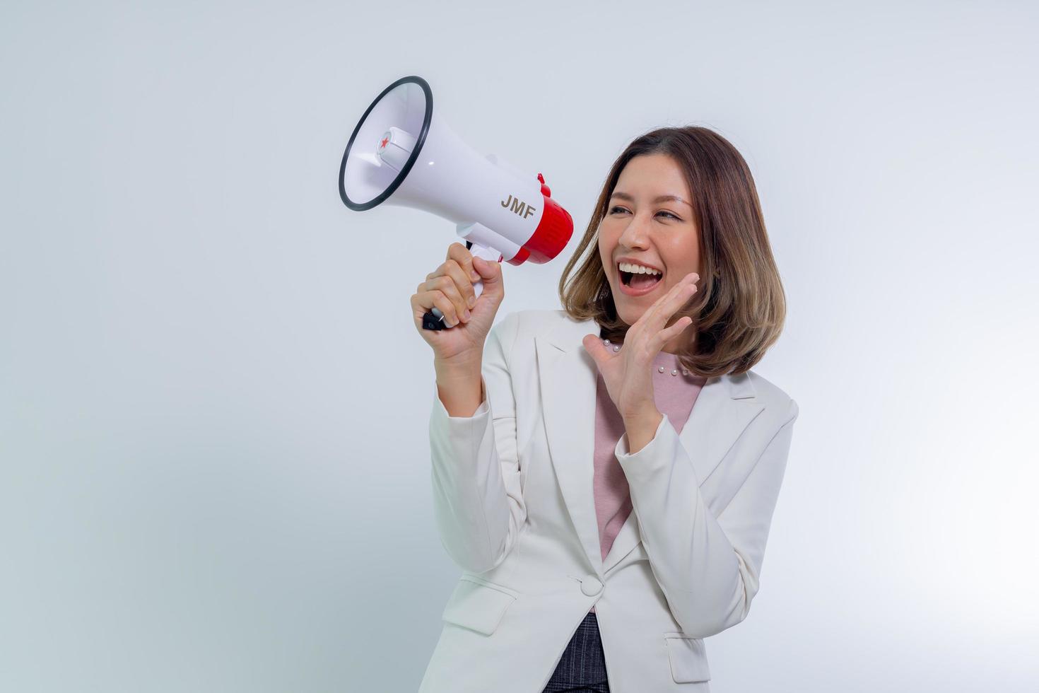 mujer asiática sosteniendo megáfono, habla y anuncia el concepto. foto