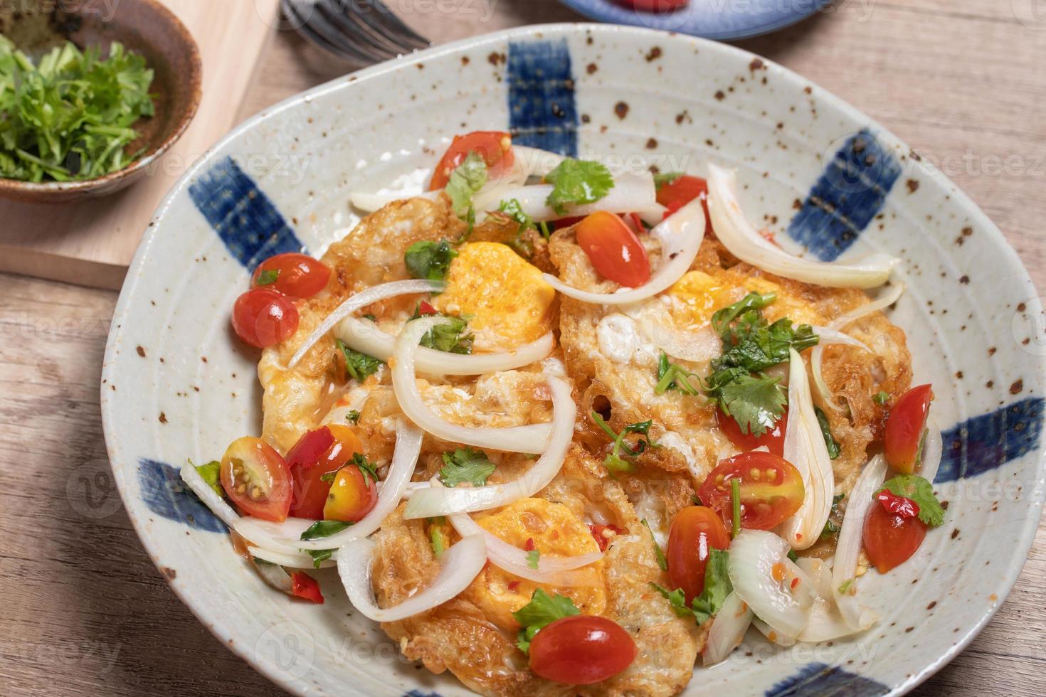 ensalada de huevo frito picante con verduras, tomates, cebollas foto