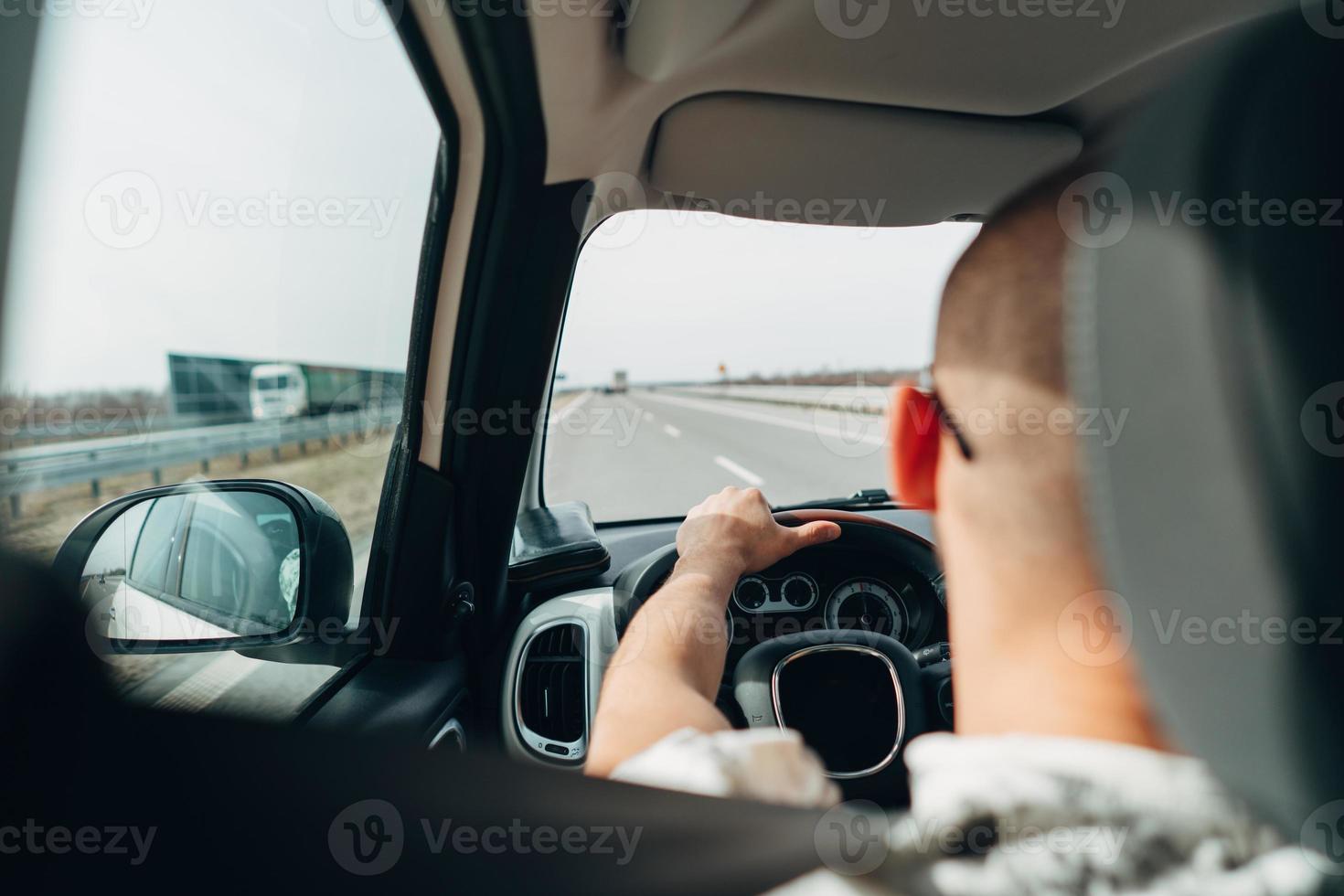 The man in the car traveling on the road photo