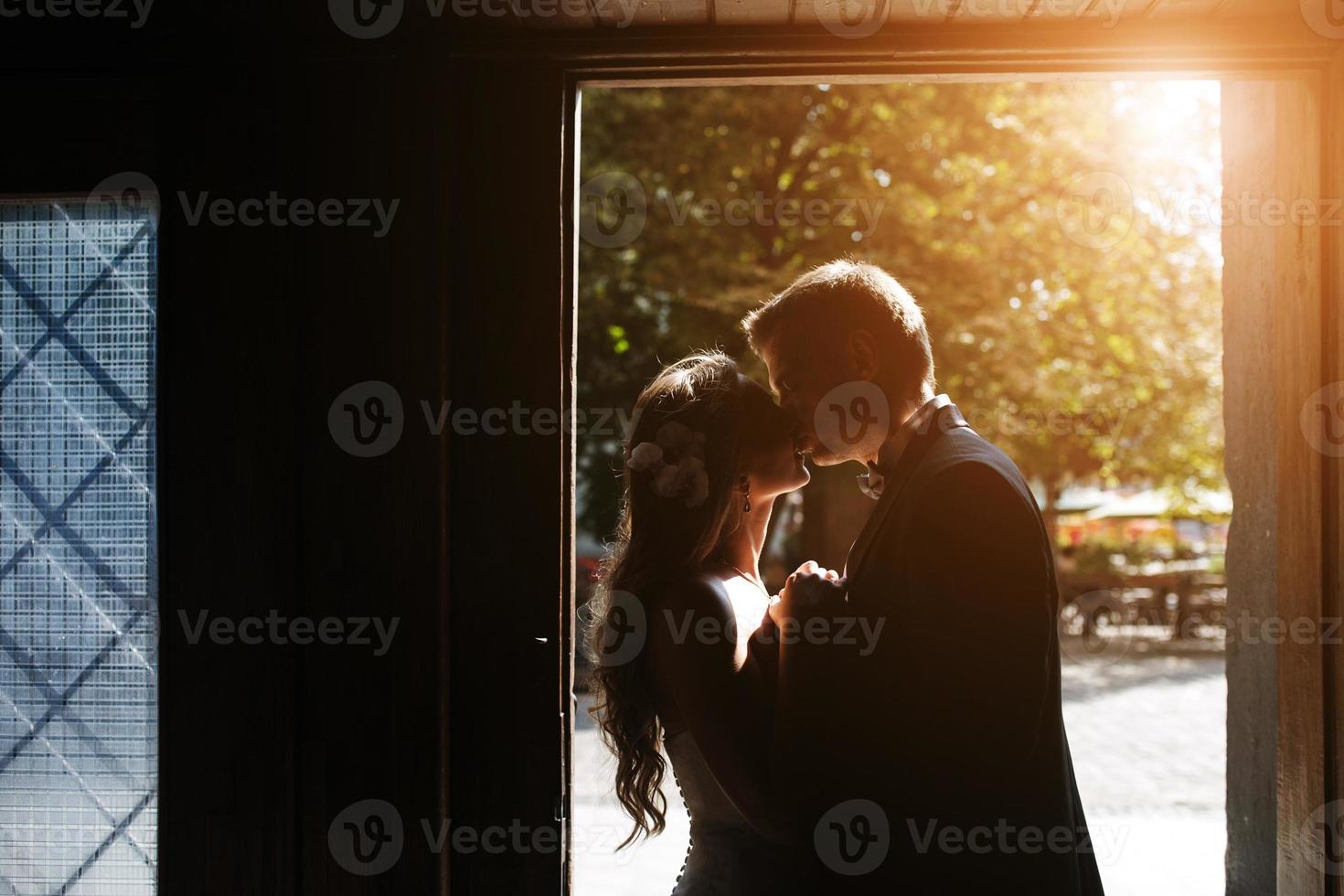 The bride and groom in a cozy house, photo taken with natural light from the window.