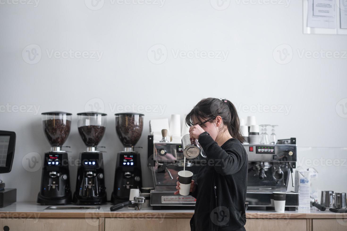 Female barista makes coffee photo